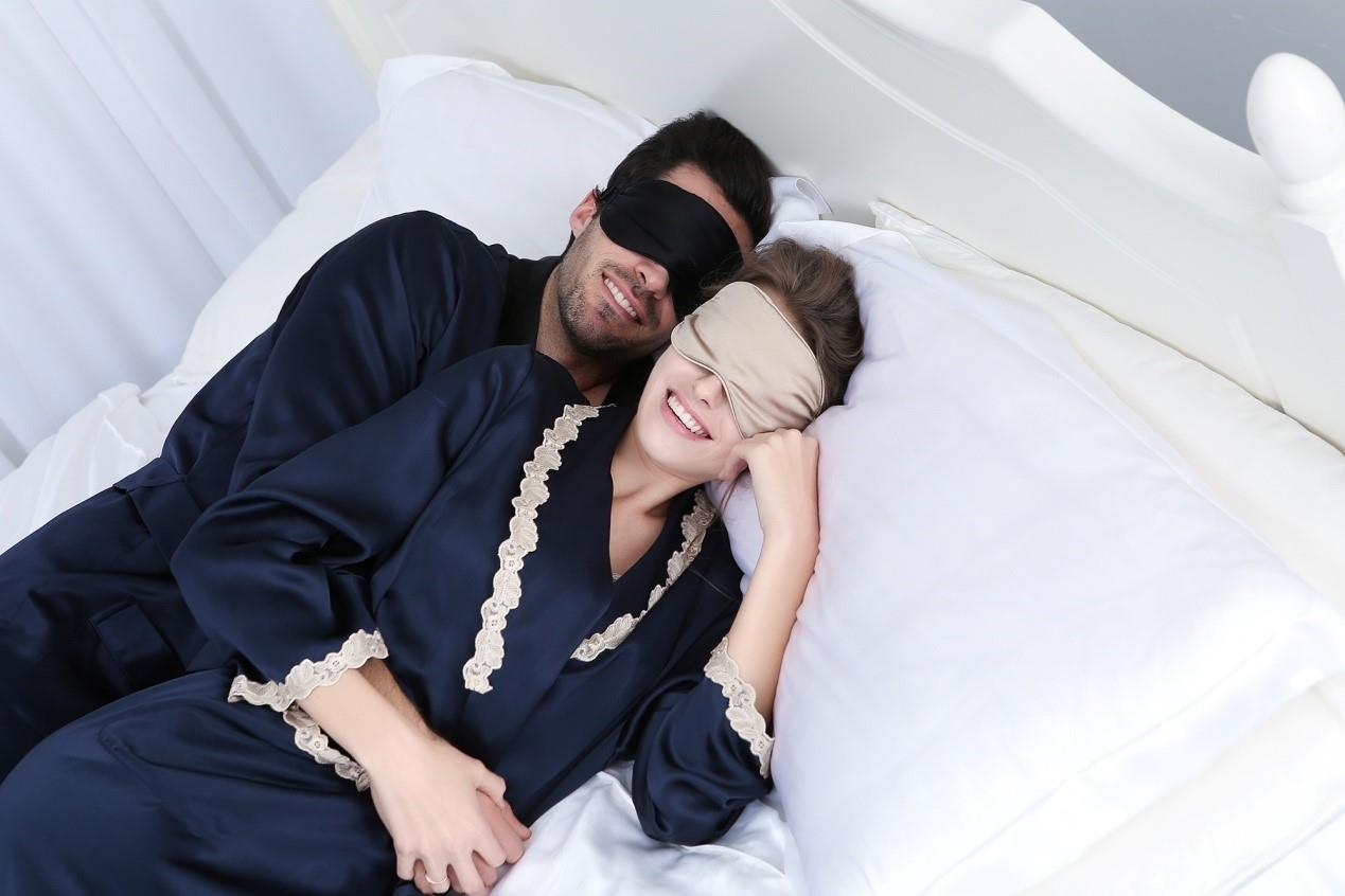 Man and woman are sleeping on the bed and wear silk eye marks